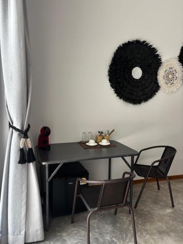 a black table with two chairs and a mirror on the wall at Villa jay in Na Mueang