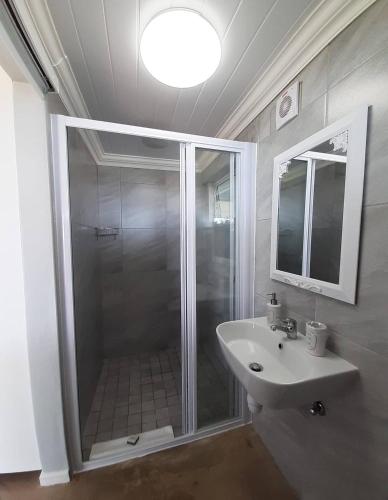 a bathroom with a shower and a sink at View on 42 - Protea Room - Small cozy room with ocean view in Mossel Bay