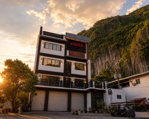 a building with a sign on the side of a mountain at Jace's Travellers Inn El Nido near Corong Corong Beach in El Nido