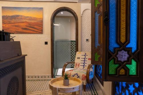 a room with a shower and a chair and a table at Riad Secret Mahjouba in Marrakesh