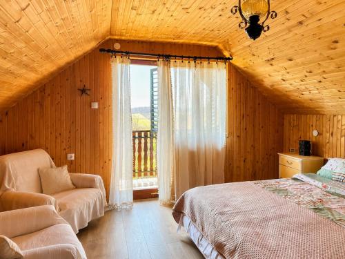 a bedroom with a bed and a chair and a window at Takovo Hills in Vrnčani