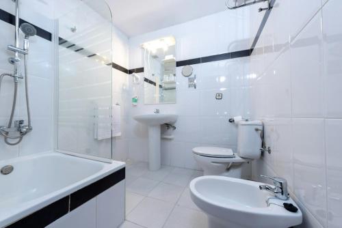 a white bathroom with a sink and a toilet at Sercotel Las Estrellas in Ciempozuelos