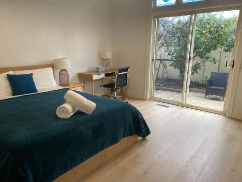 a bedroom with a bed and a desk and a window at Beach Rd Kids & Pet Friendly Free Parking in Mordialloc