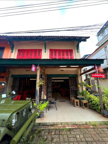a house with a red window and a patio at Via Pakse Hostel & Cafe in Pakse