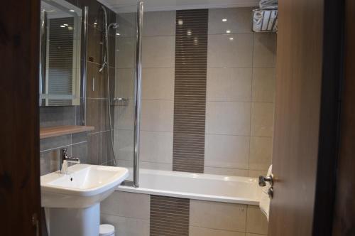 a bathroom with a sink and a tub and a toilet at Cruachan Hotel in Fort William