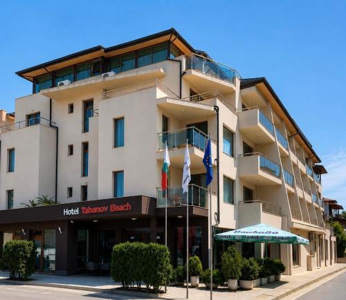 a building with flags in front of it at Tabanov Beach Hotel in Sozopol