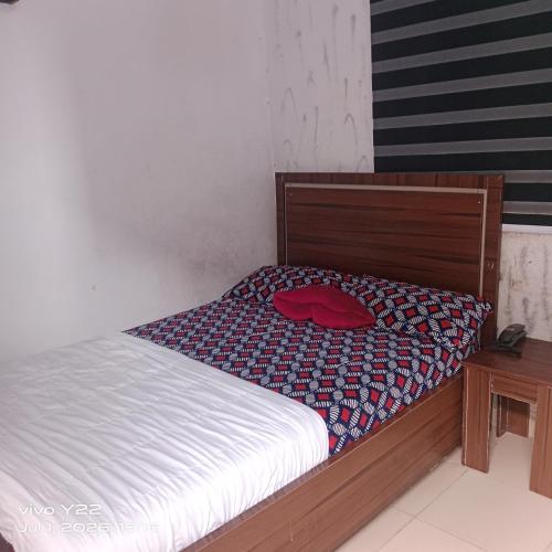 ein Bett mit einem roten Hut darauf in der Unterkunft Prince Ator Hotel in Ikeja
