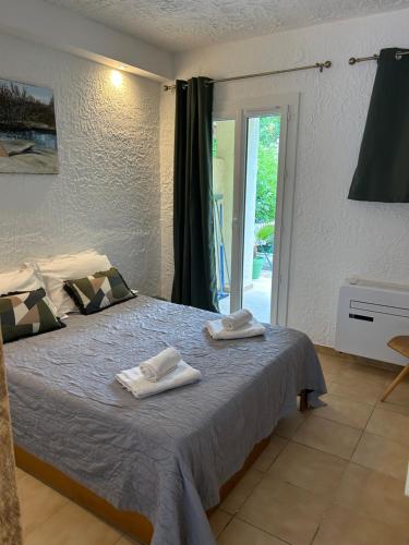 a bedroom with a bed with towels on it at Le Clos des Arbousiers in Linguizzetta