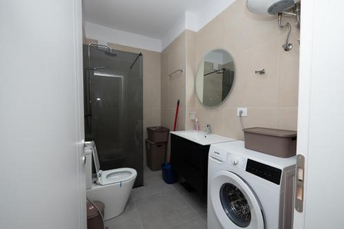 a bathroom with a washing machine and a toilet at Golem Escape in Kavajë