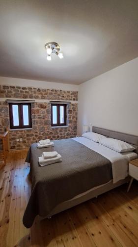 a bedroom with a large bed with two towels on it at Stone house 2 in Líthion