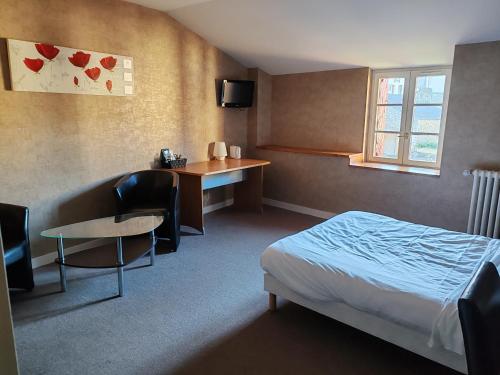 a hotel room with a bed and a table and a desk at Hotel O'Fun Art in Airvault