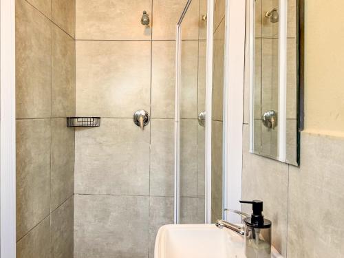 a bathroom with a shower with a sink at Cosmo Sleepover in Roodepoort