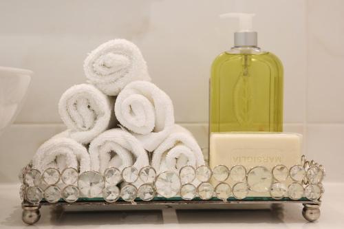 a towel rack with towels and a bottle of soap at ApartHotel Vila Minka in Ljubljana
