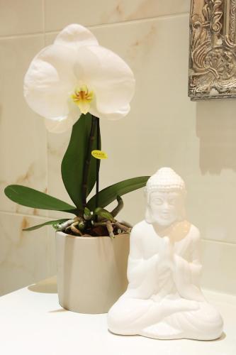 a white statue sitting next to a white flower at ApartHotel Vila Minka in Ljubljana