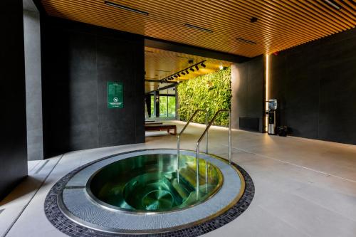 a lobby with a large tub in the middle of a building at Polanica Park, Sun&Snow in Polanica-Zdrój