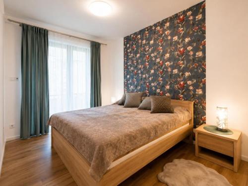 a bedroom with a bed with a large painting on the wall at Polanica Park, Sun&Snow in Polanica-Zdrój