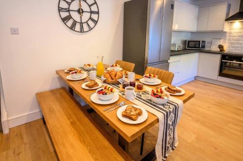 a wooden table with food on it in a kitchen at Maesteg Road - Large House - Sleeps 10 - Gateway to Afan Forest and Bike Trails in Dyffryn