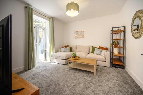 a living room with a couch and a table at Maesteg Road - Large House - Sleeps 10 - Gateway to Afan Forest and Bike Trails in Dyffryn