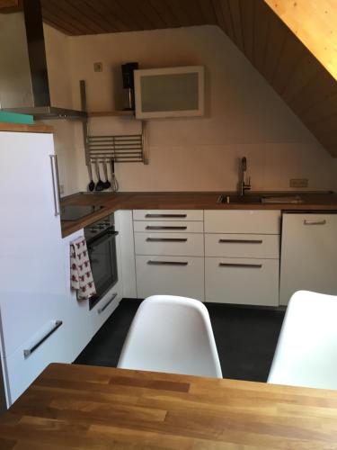 a kitchen with white appliances and a table and chairs at Im Grünen in Klein Trebbow