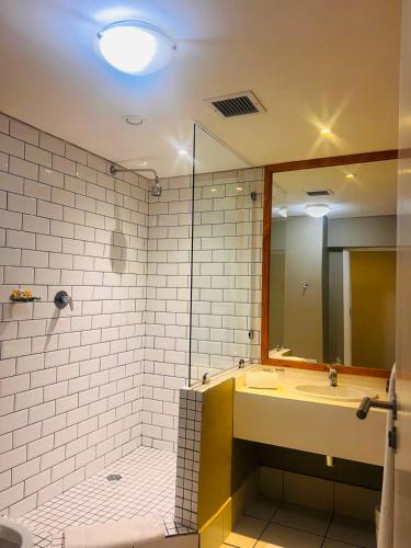 a bathroom with a sink and a shower with a mirror at Innscape Classic Hotel in Cape Town
