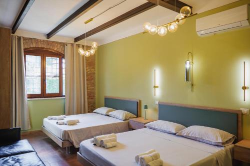 two beds in a room with yellow walls at Casale Incanto in Terracina