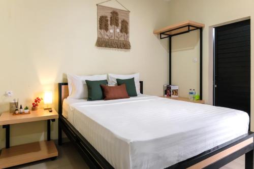a bedroom with a large white bed and a table at Rooms at Calma Villa Panorama, Batu Malang in Batu