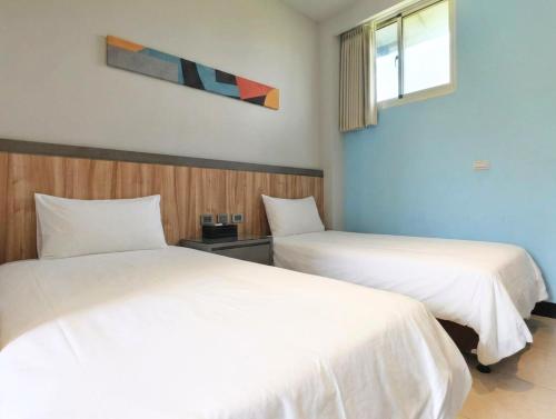 two beds sitting next to each other in a room at 好室行旅House inn 金門大學旁 近市區 in Jinning