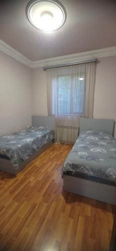 two beds in a bedroom with a wooden floor at TN Guest House in Nor Geghi