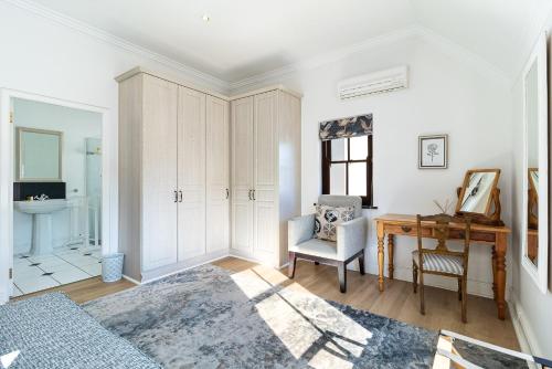 a white room with a desk and a chair at Winelands Golf Lodges 11 in Stellenbosch