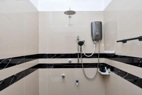 a bathroom with a shower with a phone on the wall at Bay Marina in Arugam Bay