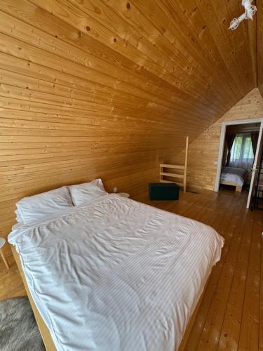 a bedroom with a bed in a wooden room at Roua Munților in Dârlești