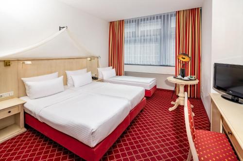 a hotel room with a large bed and a television at Hotel Chateau Berlin Kurfürstendamm in Berlin