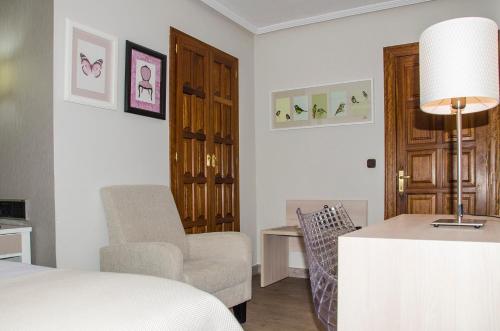 a bedroom with a bed and a chair and a table at Hotel Presa in Riaño