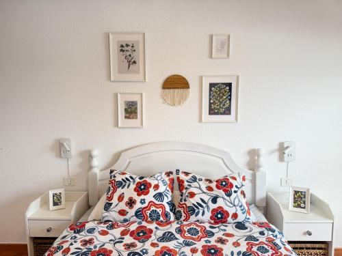 a bedroom with a white bed with a floral bedspread at Apartamento Maye in Bajamar