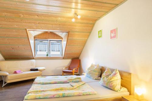 a bedroom with a bed and a chair in a room at Die Moderne Fewo in Breitenberg