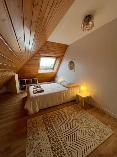 a bedroom with a bed and a wooden ceiling at Maison cozy in Saint-Brieuc