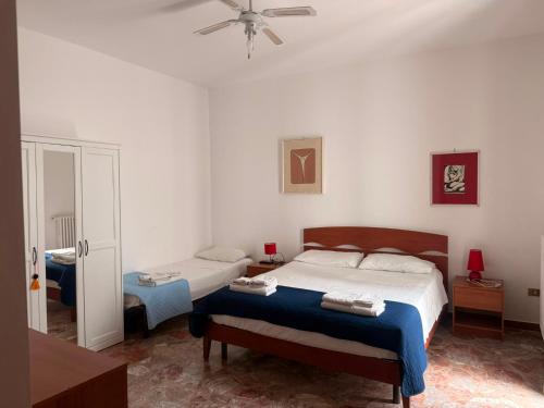 a bedroom with two beds and a ceiling fan at Casa Raffaella in Polignano a Mare