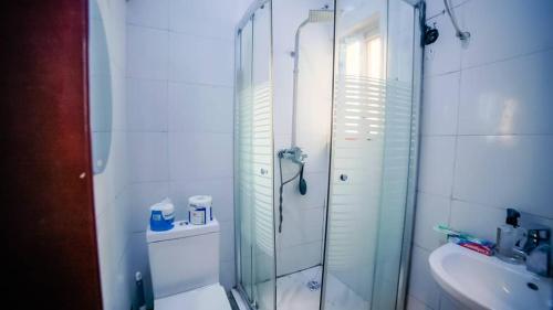 a bathroom with a glass shower and a sink at CBC Towers in Lagos
