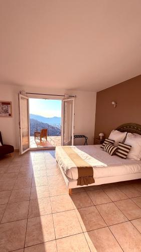 a bedroom with a large bed and a large window at la maison CM in Nessa