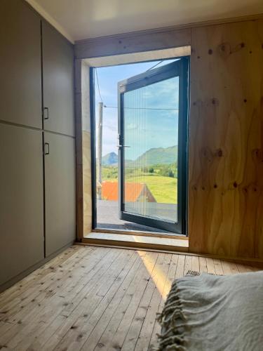 a bedroom with a large window with a view at Nykmark Eco Residence in Unnstad