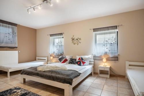 a bedroom with two beds and two windows at Eifel Dream Zingsheld in Fleringen