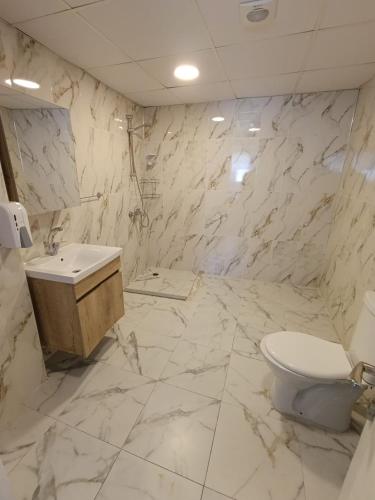 a marble bathroom with a toilet and a sink at Blacktree Edirne in Edirne