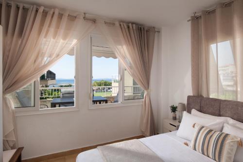 a bedroom with a bed and a large window at Silvia's Haus in Neos Marmaras