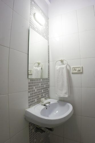 a white bathroom with a sink and a mirror at Hotel highway inn in Gandhidham