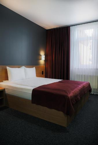 a bedroom with a large bed with a window at HOUSE silver in Ivano-Frankivsk
