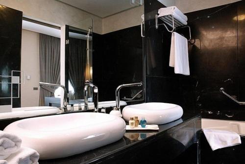 a bathroom with two sinks and a large mirror at Imperial Casablanca Hotel & Spa in Casablanca