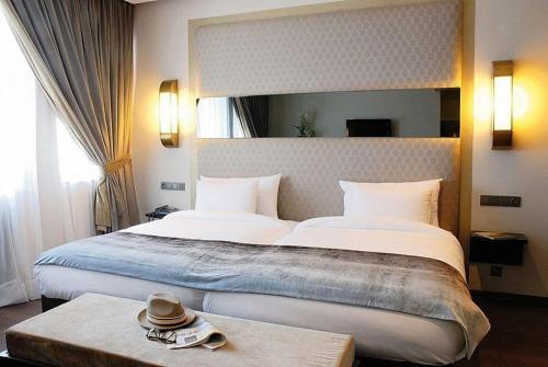 a bedroom with a large bed with a hat on a table at Imperial Casablanca Hotel & Spa in Casablanca