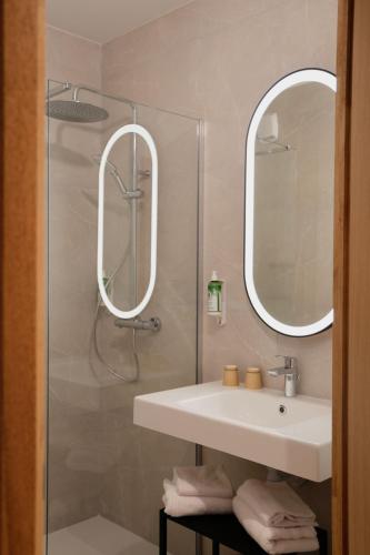 a bathroom with a sink and a shower with two mirrors at B&B HOTEL Bastia in Bastia