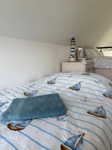 a bed with a blue blanket and shoes on it at Lazurowy Brzeg in Przejma Wielka