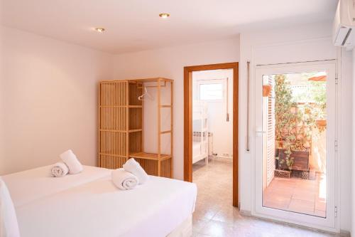 two white beds in a room with a sliding glass door at Majordoms Ponent in Banyoles